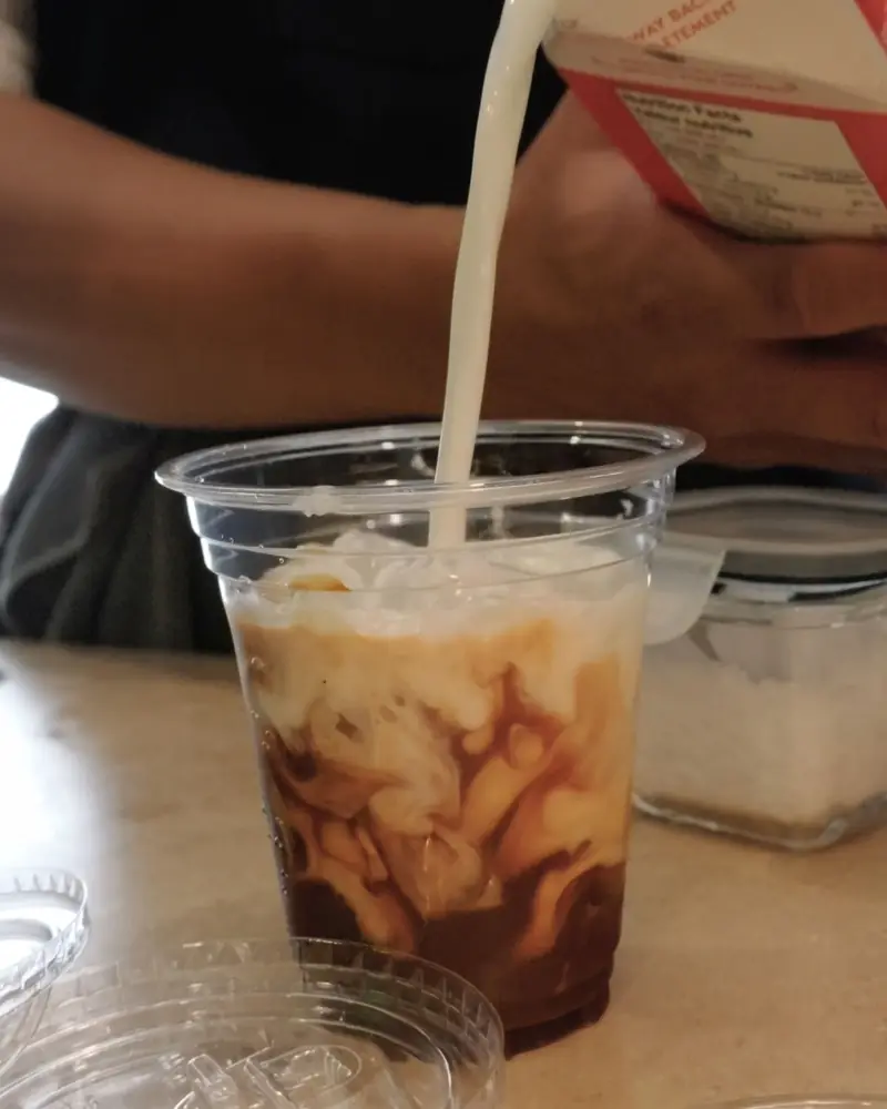 Milk poured into an iced latte on the Lucky Coffee cart